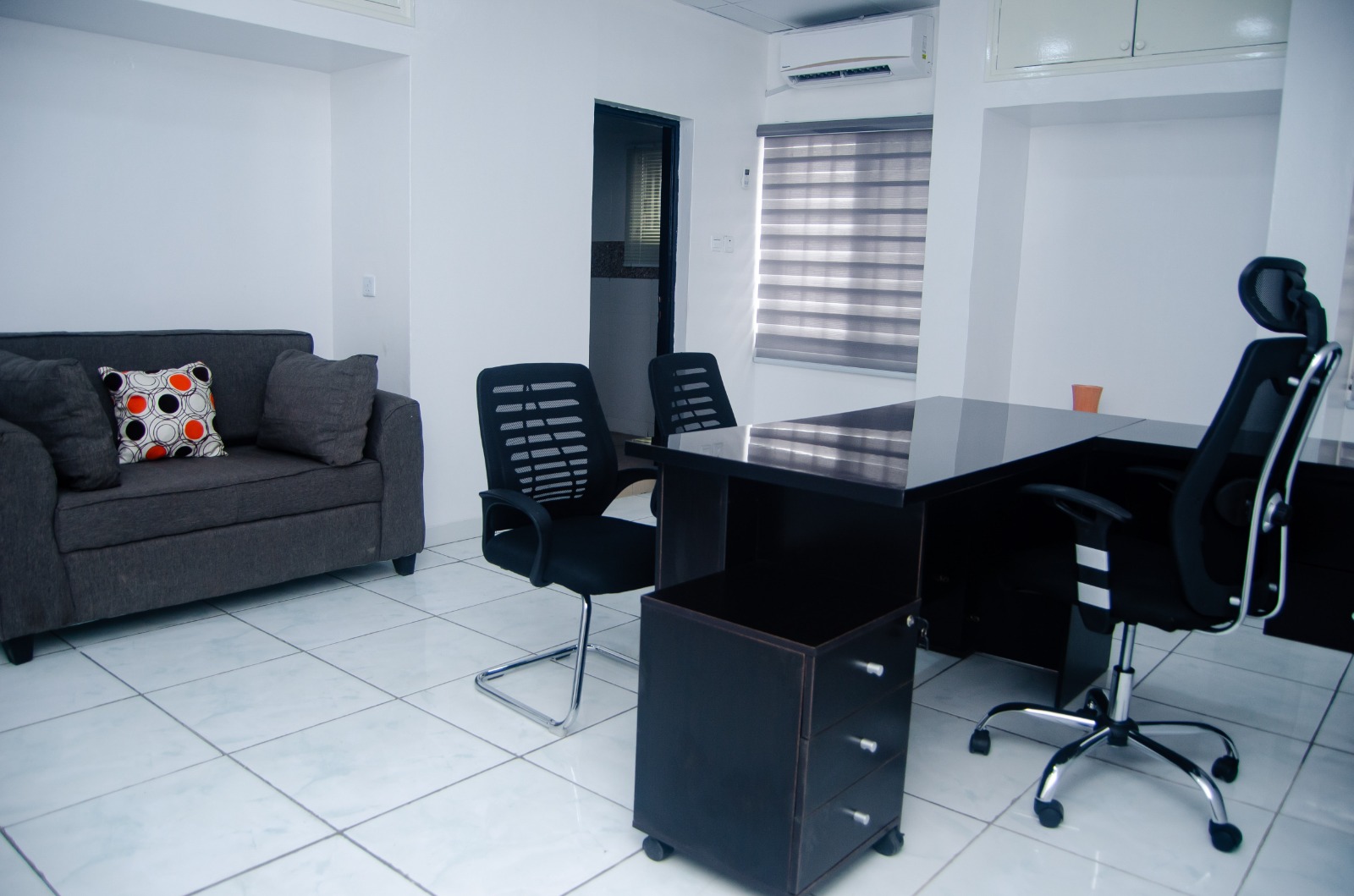 Compact workspace with grey lounge seating and black desk