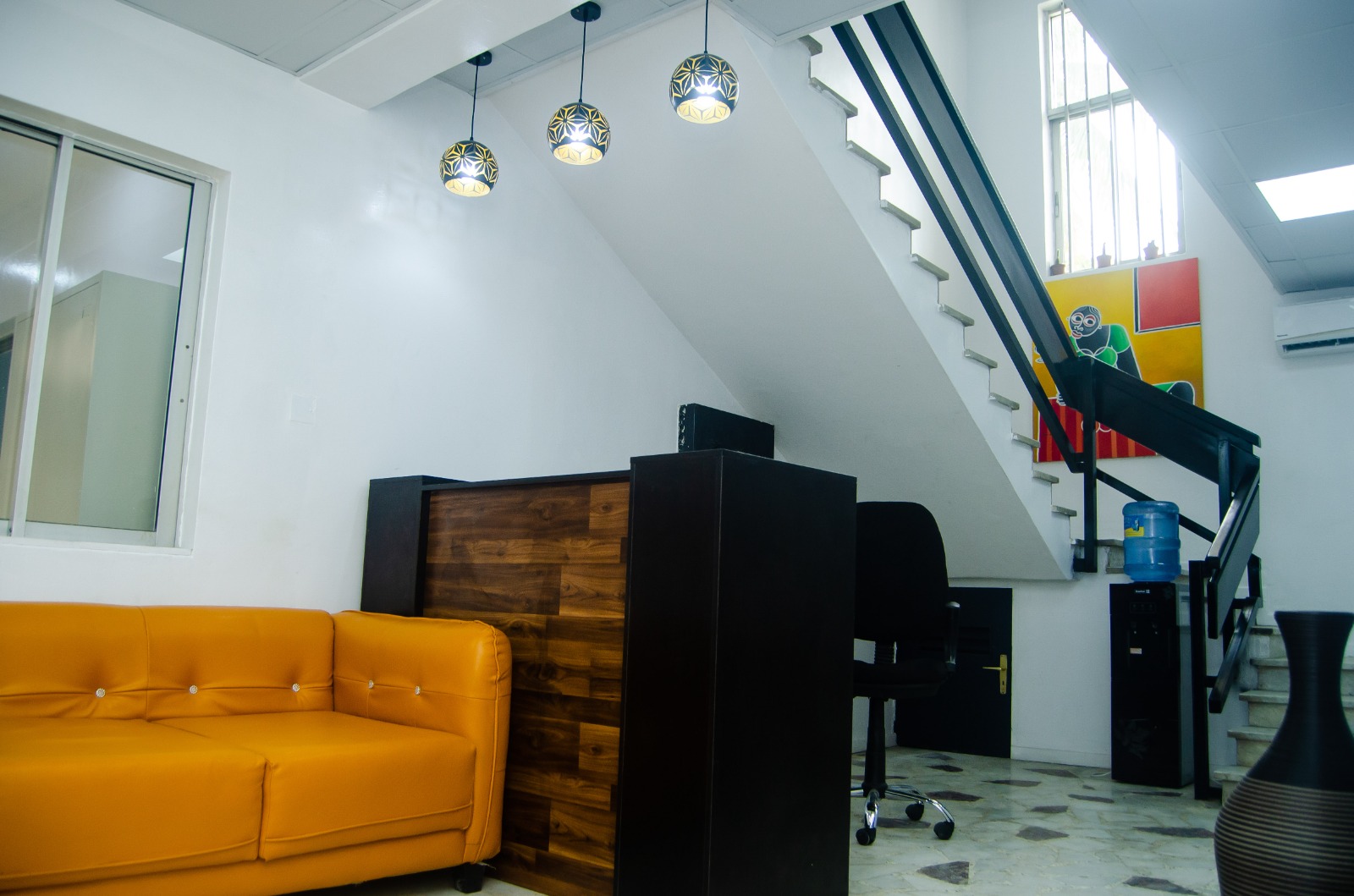 Reception and lounge area with stairs and orange sofa